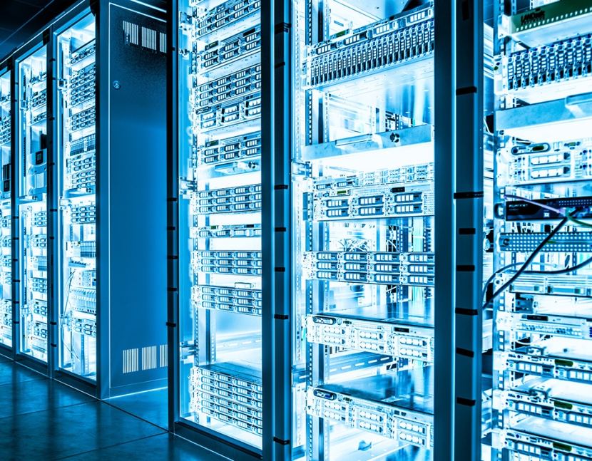 Servers in rows on metal shelves in dark cooling room